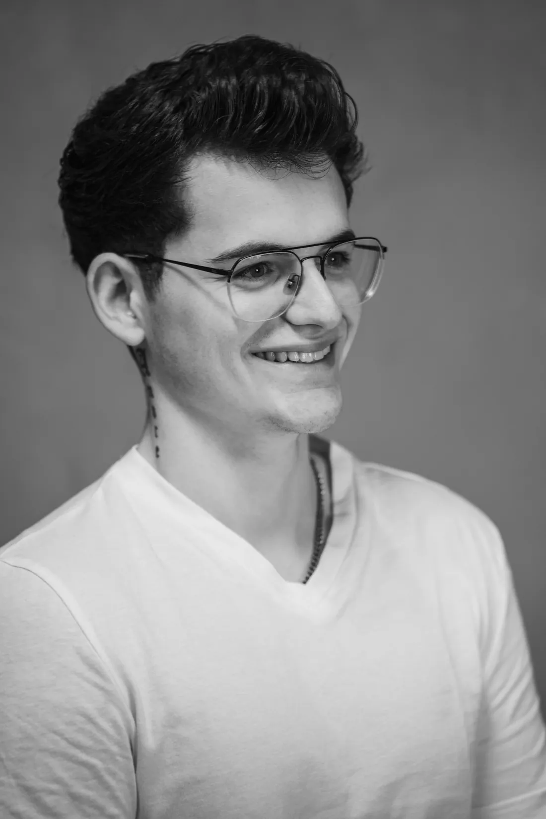 Porträt von Noah Nestler in Schwarzweiss, lachend mit Brille