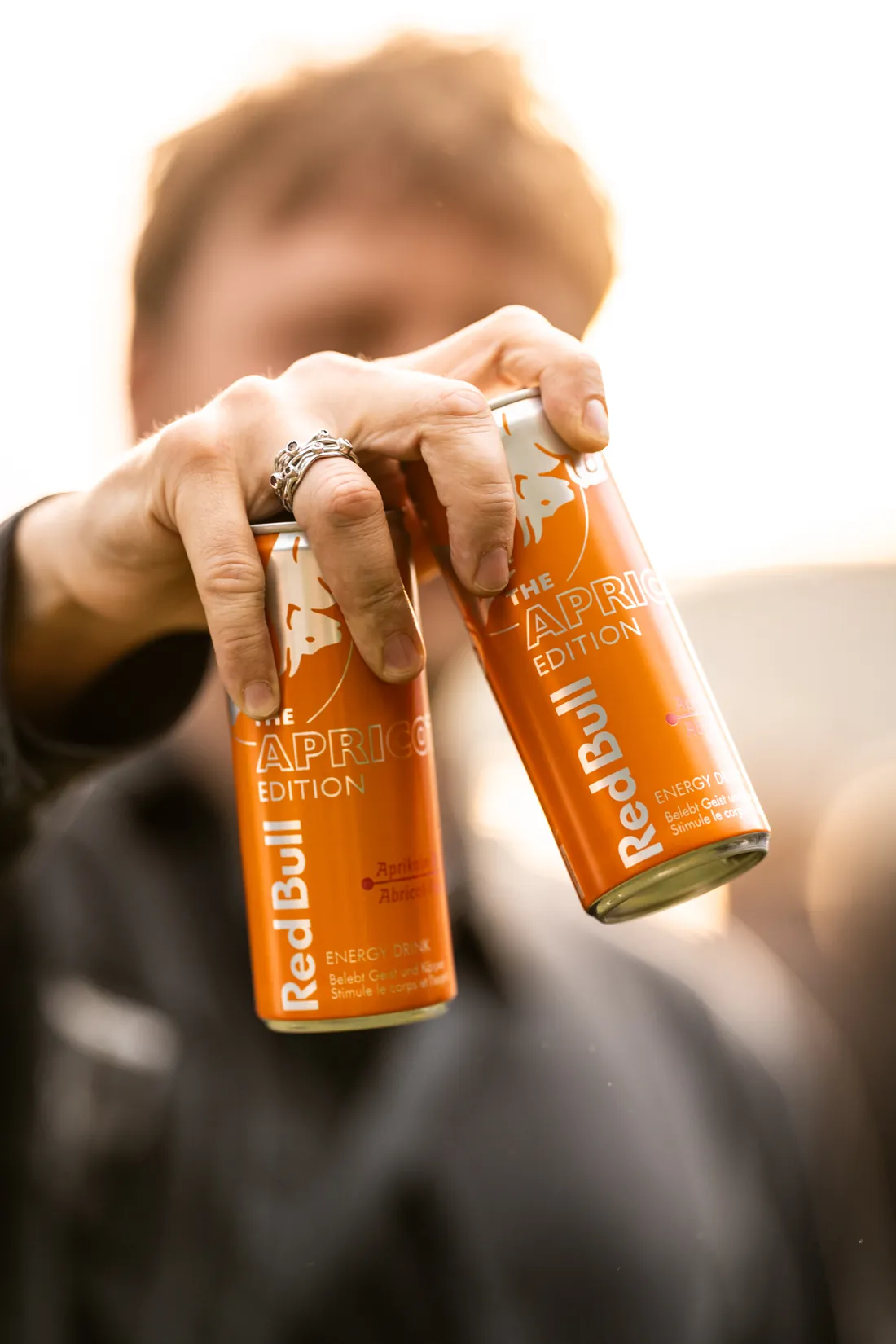 Hand mit zwei Dosen eines Energy-Drinks an einem Firmenanlass