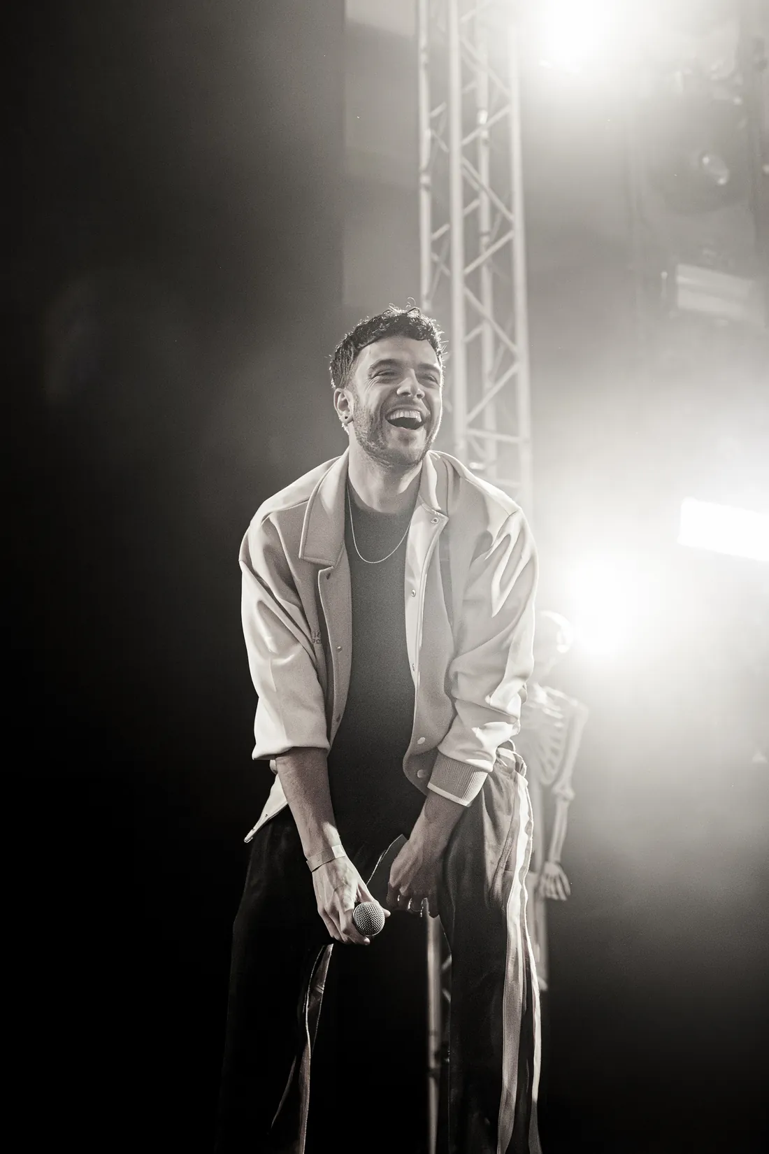Musiker lacht auf der Bühne im Gegenlicht