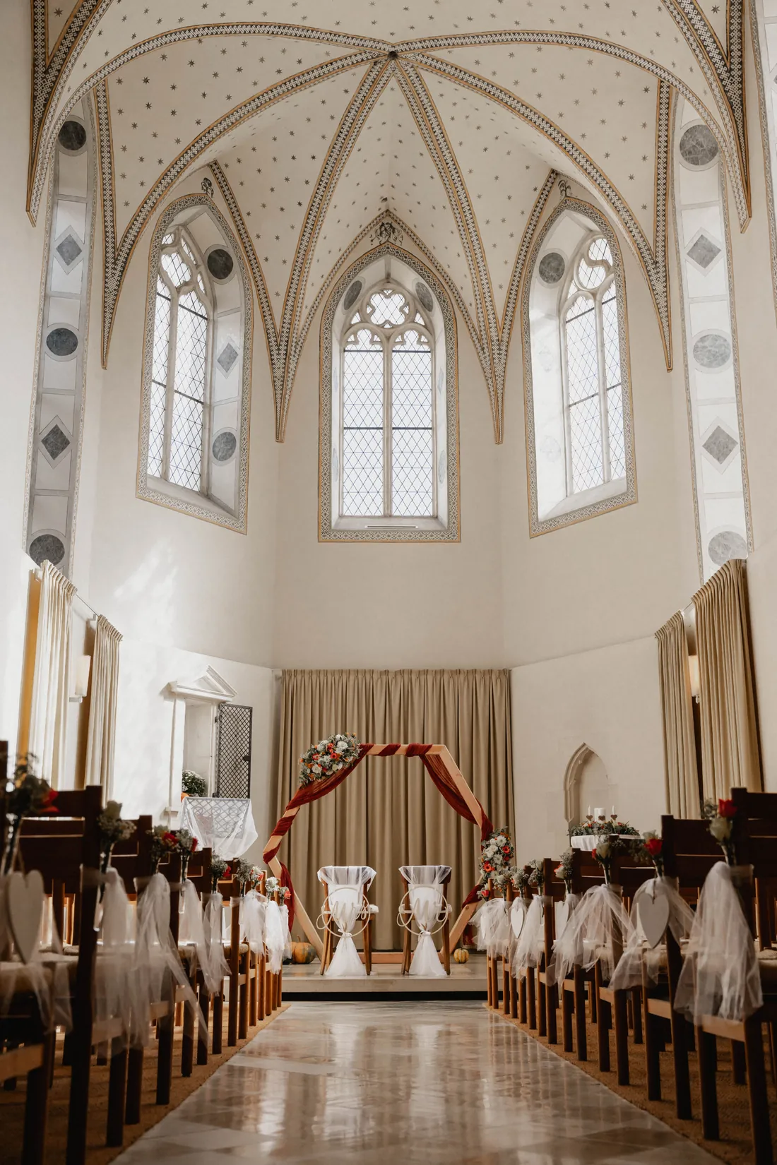 Mittelgang einer weiss geschmückten Kirche