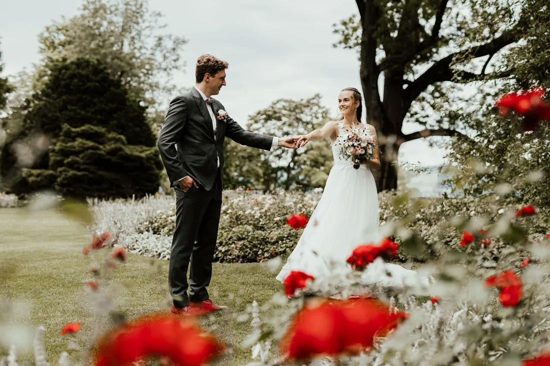 Brautpaar im Rosengarten, rote Rosen im Vordergrund