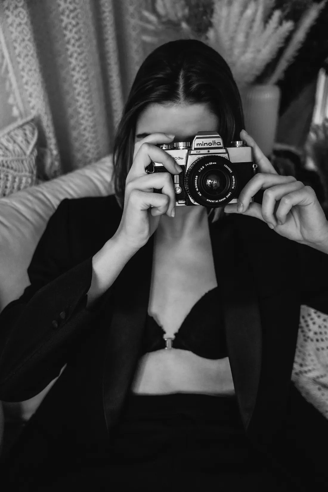 Frau fotografiert mit einer Spiegelreflexkamera in die Linse, Schwarzweiss